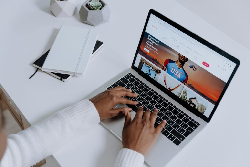 Pessoa digitando em um notebook com gráficos de lucro e dólar ao redor — representando monetização de blog.